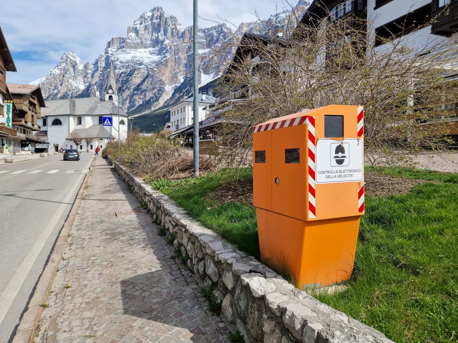 Italian Toll Roads: How To Pay and Use Italian Autostrada 8 an orange speed camera on a road in a village in the dolomites